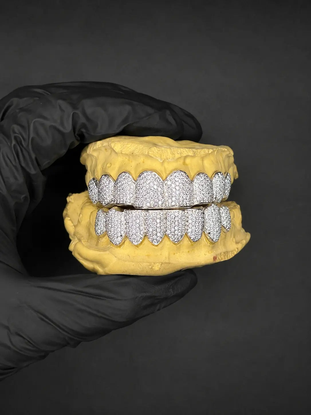 Three-quarter angle view of fully iced out custom bustdown VVS-Moissanite grillz