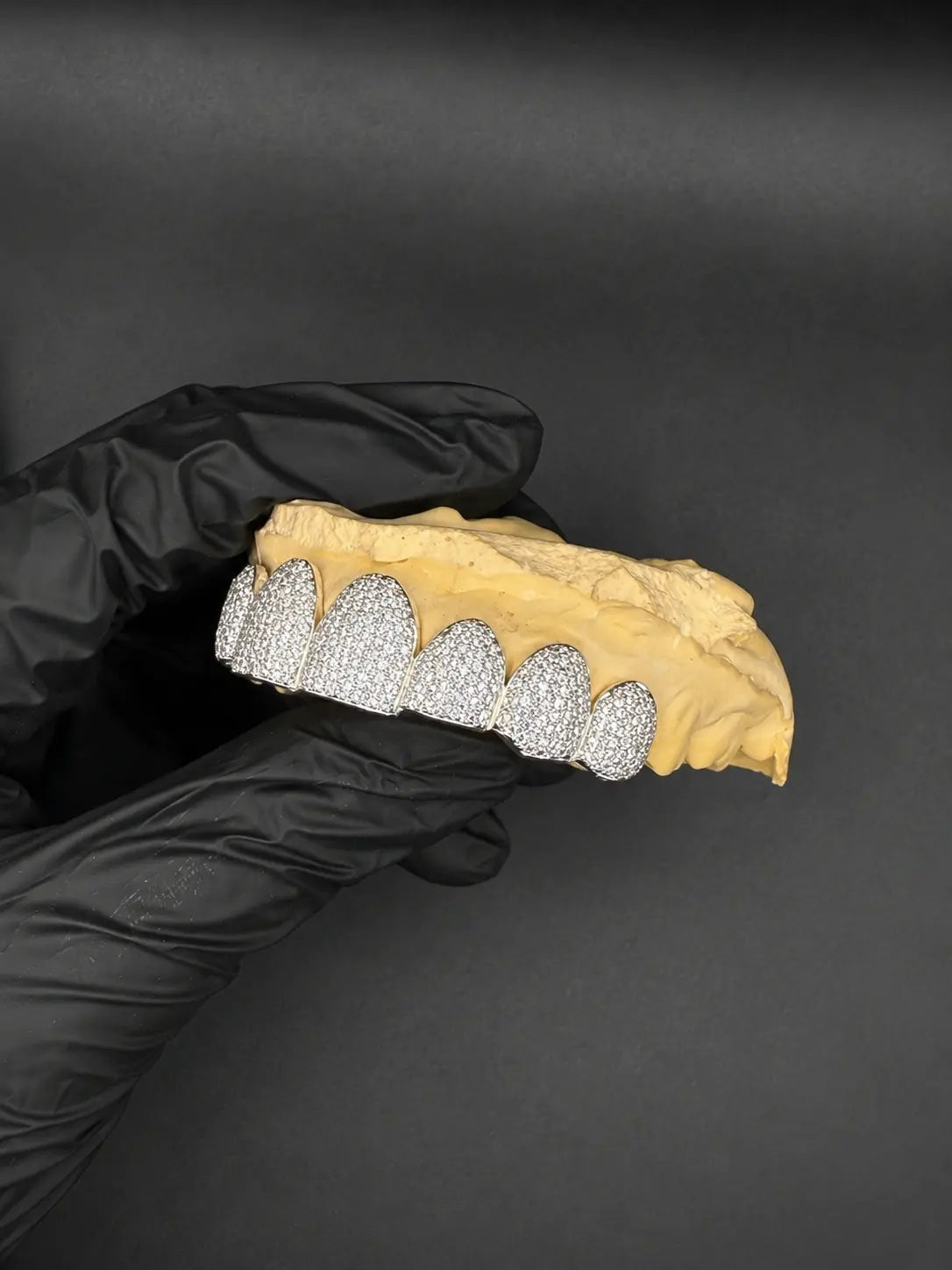 Side profile of luxury bustdown VVS-Moissanite grillz in silver and gold