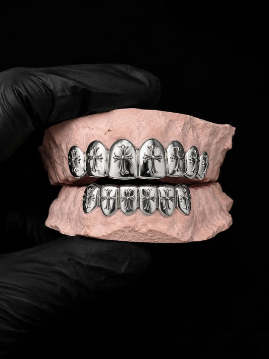 Custom CAD-designed cross grillz in sterling silver displayed on a dental mold with black luxury background