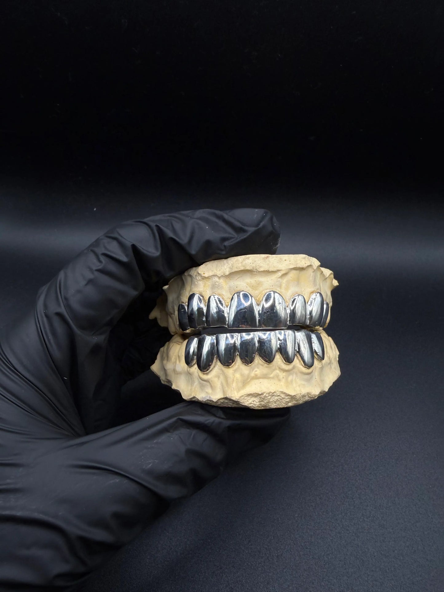 Custom handmade grillz displayed in hand showing luxury craftsmanship