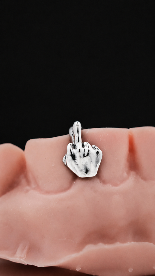 Custom sterling silver middle finger grillz tooth cap on dental model with black background