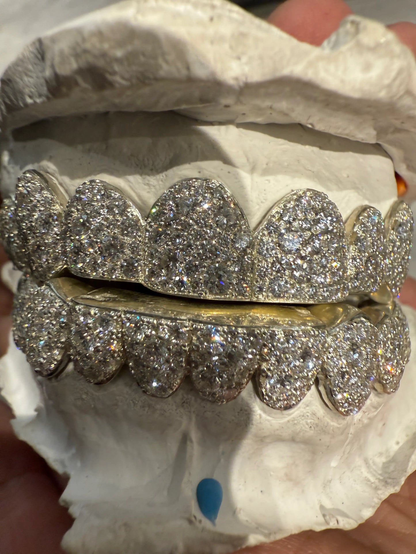 Close-up detail of hand-set VVS moissanite stones on mosaic grillz