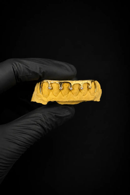 Custom drip style 6 teeth grillz with Lab VVS diamonds in gold finish on black background