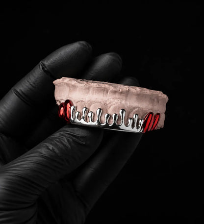 Close-up detail of handmade sterling silver dripped grillz with polished red plated accents