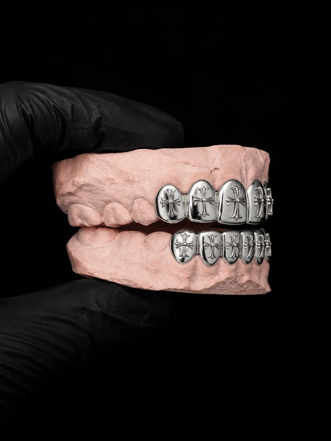 Side angle view of custom silver cross grillz with detailed engraved crosses and dental-grade fit