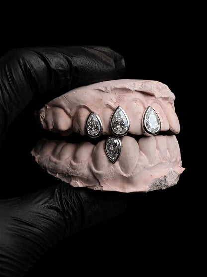 Close-up of luxury pear-cut diamond grillz handcrafted in solid gold with VVS stones