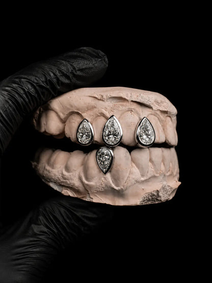 Custom pear-cut diamond grillz with VVS stones in silver front view on black background