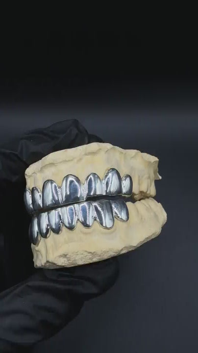 Custom handmade grillz in solid silver or gold sparkling under light with precision fit